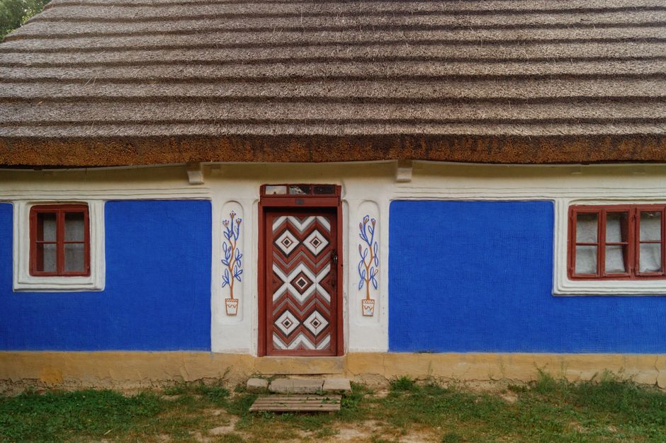 Small house with blue painted walls and a thatched roof