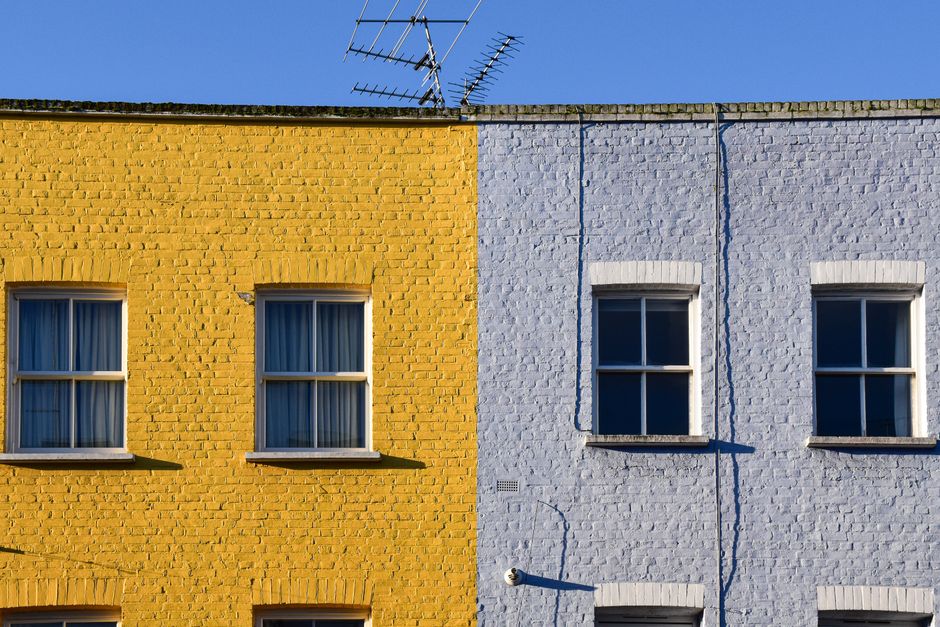 Yellow and blue painted house fronts in daylight.