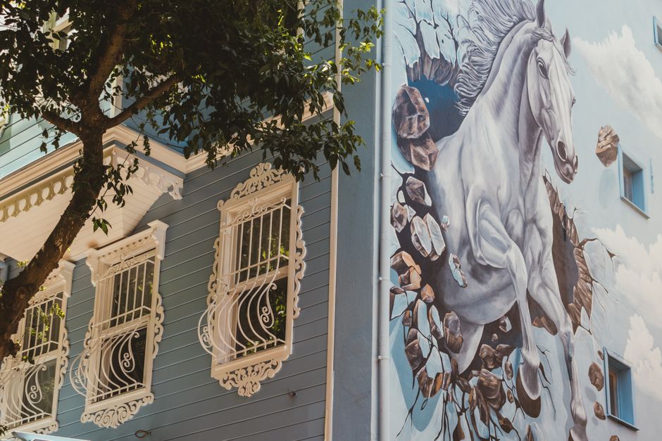 Blue painted house wall with decorative windows.